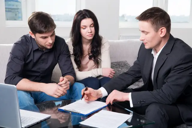 Homeowners reviewing an insurance claim with an adjuster
